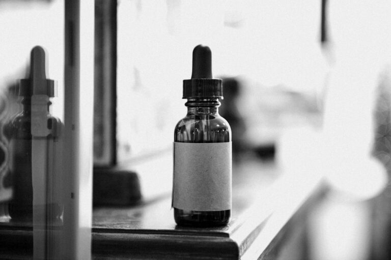 Flacon d'huile à barbe posé près d'un compte-gouttes